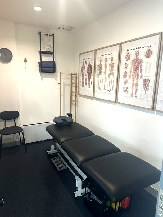 The treatment room, massage table and anatomy charts